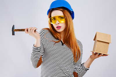 戴蓝头盔的女孩拿着锤子图片下载