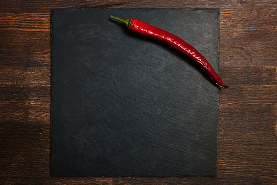 木桌上的盘子里放着红辣椒图片下载