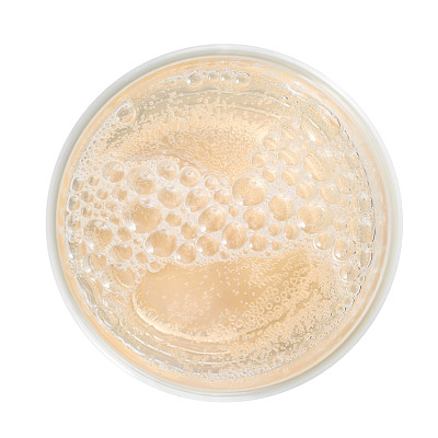 苹果酒近景，俯视图。淡黄色泡沫饮料与泡沫和简单的玻璃杯。图片下载