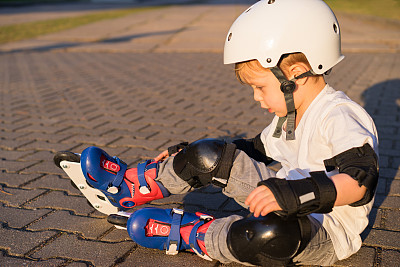那孩子滑旱冰时摔倒了图片下载