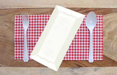 盘子放在桌布上，勺子和叉子作为食物的背景图片下载