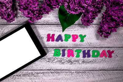 生日快乐概念与顶视图和复制空间。木桌上放着丁香花和写字板。图片下载