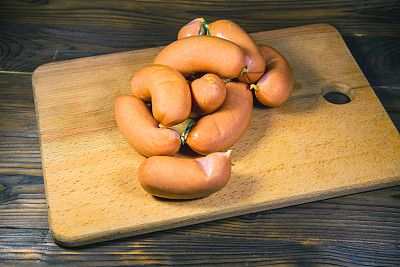 香肠放在木桌上的砧板上图片下载