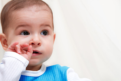 可爱的婴儿近距离肖像在白色的背景和看一边图片下载