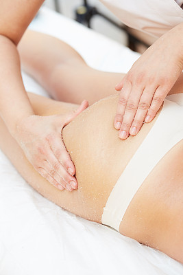 在健康水疗中心接受盐磨砂美容治疗的女人图片下载