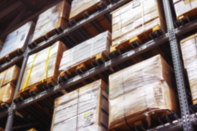 仓库内部模糊处理。一排排放着盒子的架子图片下载