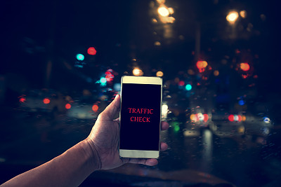在车里手持智能手机检查交通。图片下载