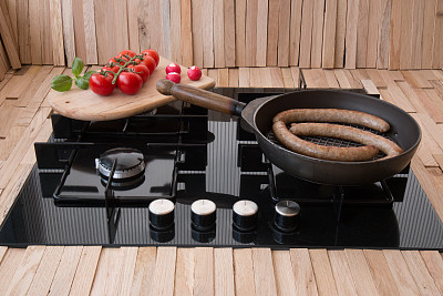 美味的香肠在锅里的炉子和蔬菜图片下载