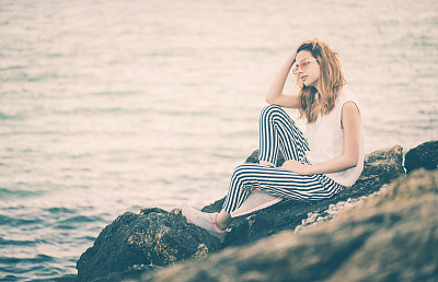 年轻女孩在海边休息。图片下载