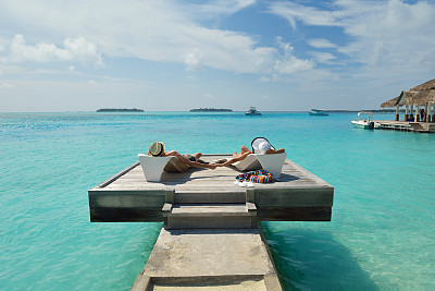 快乐的年轻夫妇在海滩上玩得开心图片下载