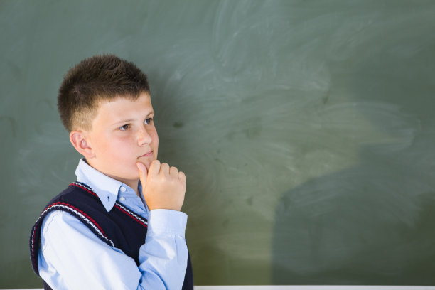 在黑板前思考的男孩图片下载