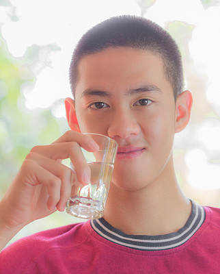 亚洲酷年轻人拿着一杯水图片下载