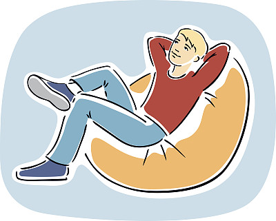 年轻的金发男人坐在豆袋椅上图片下载