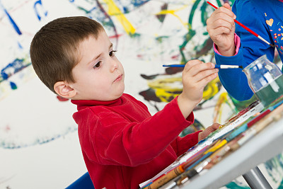 可爱的男孩聚精会神的画画图片下载