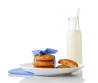 燕麦饼干，半块饼干放在盘子里和牛奶瓶里图片下载