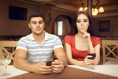 好奇的女孩在智能手机上监视男友图片下载