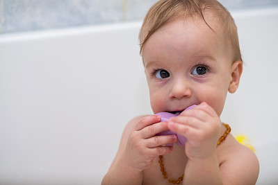 可爱的小男孩一边洗澡一边吃玩具图片下载