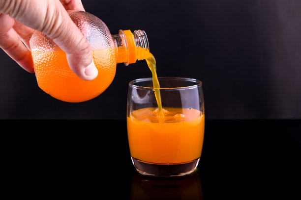 将橙汁倒入玻璃杯中图片下载