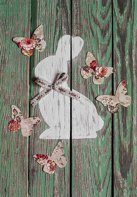 复活节装饰-兔子和纸蝴蝶在木制的背景图片下载