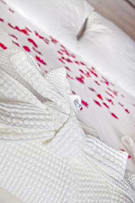 水疗酒店的浪漫卧室。玫瑰花瓣和晨衣图片下载