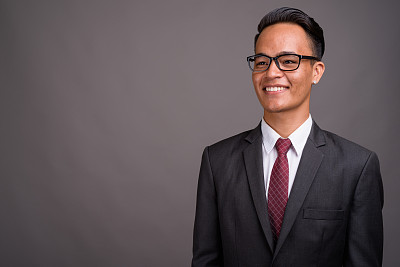 在灰色背景下拍摄的年轻印度商人图片下载