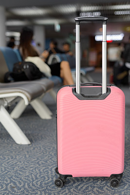 适合轻型旅行的粉红色手推车行李的肖像与机场的视野相反图片下载