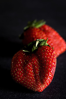 新鲜的草莓放在旧的黑色木桌上图片下载