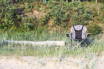 夏日日落时，坐在海滩边的椅子上图片下载