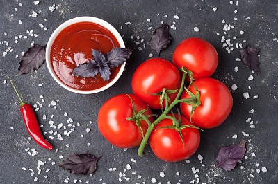 蕃茄酱在碗里与罗勒，香料和番茄在黑暗的桌子上。俯视图图片下载