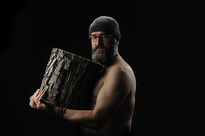 胡子男子手里拿着一根木头，背景是黑色的图片下载