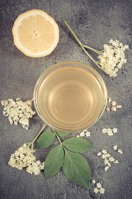 复古照片，新鲜健康的果汁，接骨木花和柠檬在混凝土结构上图片下载