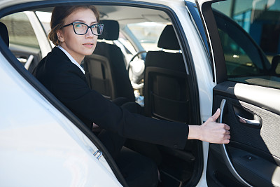 女商人坐在汽车的后座上图片下载