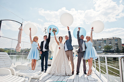 新婚夫妇，伴郎和伴娘在码头上玩气球。图片下载