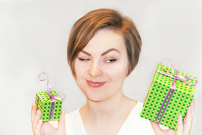 那个女孩拿着大大小小的礼品盒。图片下载