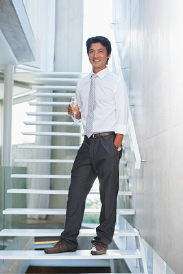 严肃的男人拿着香槟长笛看着镜头图片下载