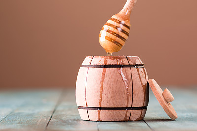 蜂蜜用木勺盛在木碗里，放在木桌上图片下载