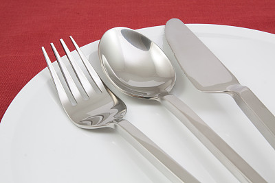 在红色桌布上用叉子和刀特写盘子图片下载