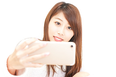 年轻女子微笑着用智能手机图片下载