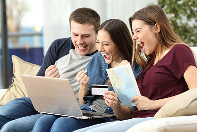 兴奋的朋友在网上购买旅行素材图片