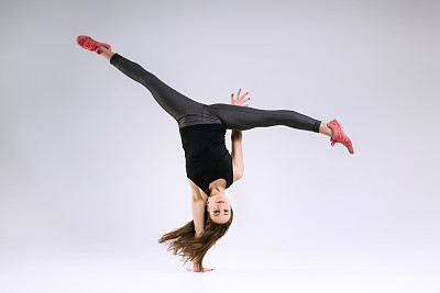 在灰色背景上跳跃的女孩图片下载