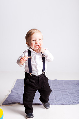 男孩在白色背景上用嘴叼着他的手指图片下载