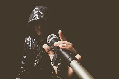 手的亚洲英俊歌手在动态麦克风图片下载