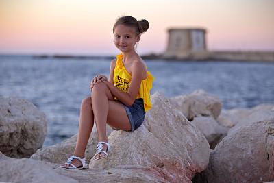 小女孩坐在石头上图片下载