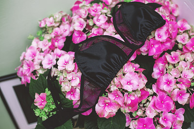 女性黑色蕾丝胸罩上的花朵背景。手工制作的蕾丝胸罩图片下载