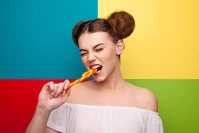 穿白色上衣的女孩在咬拐杖糖图片下载