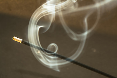 在黑暗的背景上燃烧着烟熏香图片下载