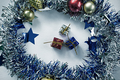 复古圣诞礼物色调的照片。蓝色，红色和银色包裹的圣诞礼物在花圈。图片下载