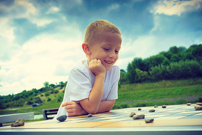 小男孩在公园玩跳棋图片下载