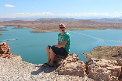 年轻人坐在岩石上。图片下载