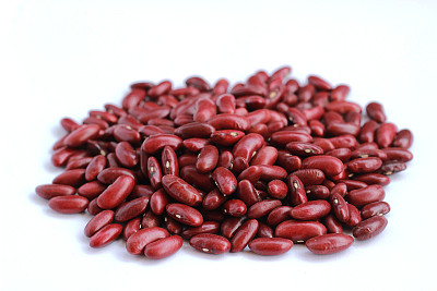 白色的背景上点缀着美丽的红豆种子图片下载